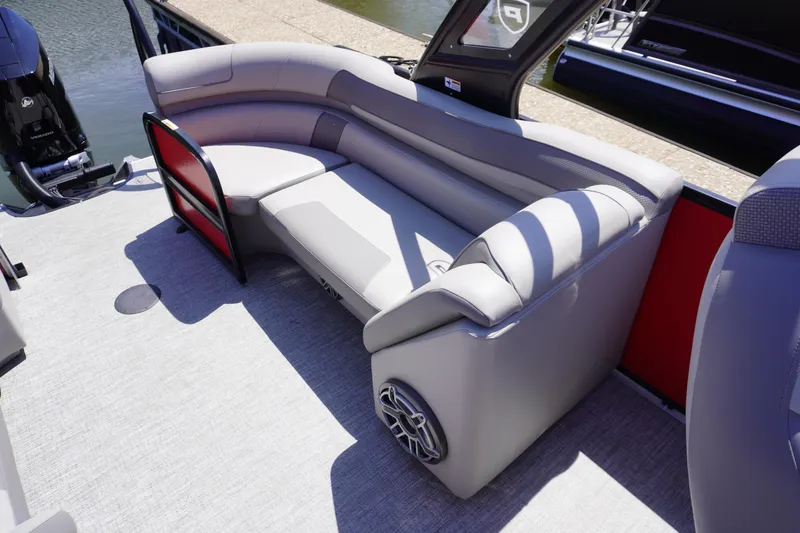 Slide: The Image of 2024 Premier 250 Solaris boat interior with curved seating and speaker, dockside view. - 6