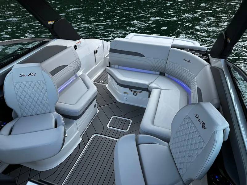 Slide: The Image of 2025 Sea Ray SLX 260 boat interior with luxurious seating and ambient lighting on the water. - 11