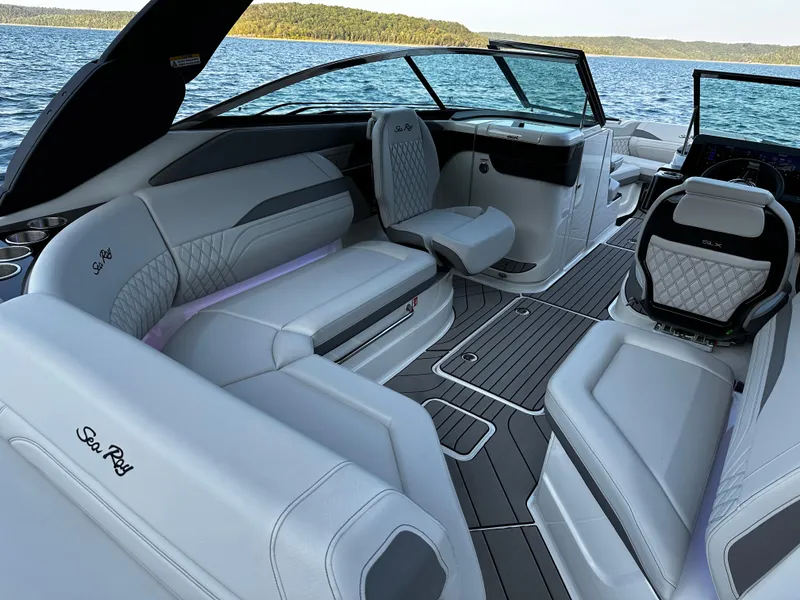 Slide: The Image of 2025 Sea Ray SLX 260 boat interior with luxurious seating and modern design on a serene lake. - 13