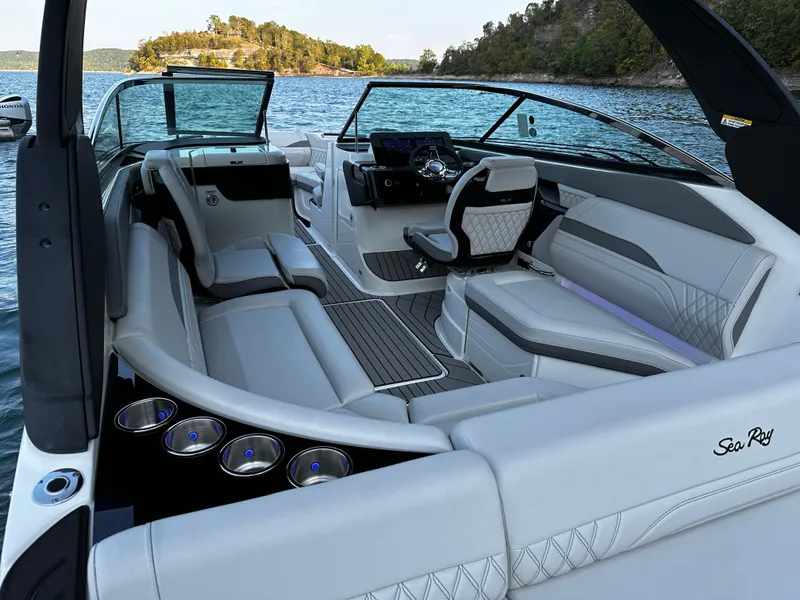 Slide: The Image of 2025 Sea Ray SLX 260 boat interior with luxurious seating on a serene lake. - 17