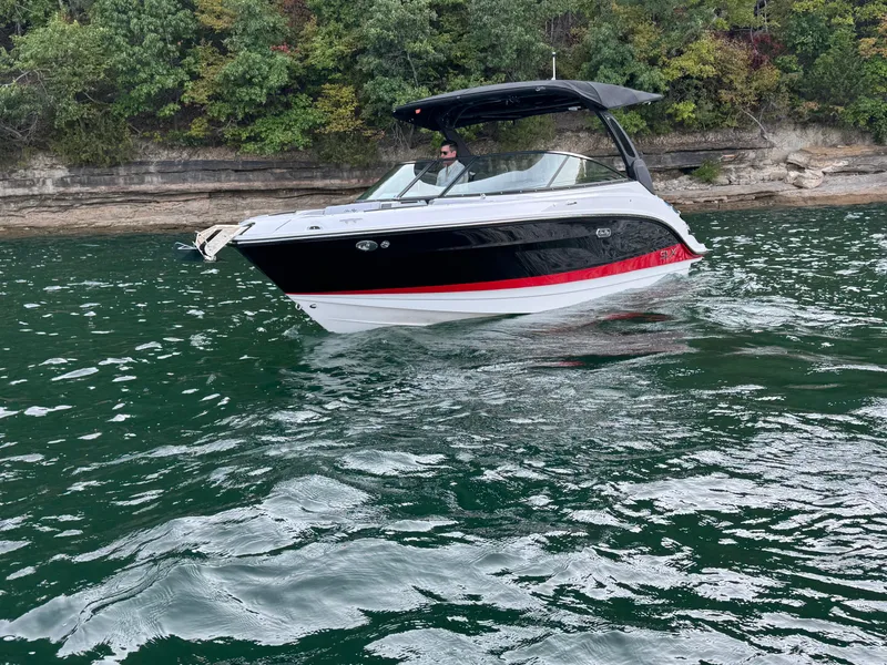 Slide: The Image of 2025 Sea Ray SLX 260 boat cruising on a scenic lake with lush greenery. - 3