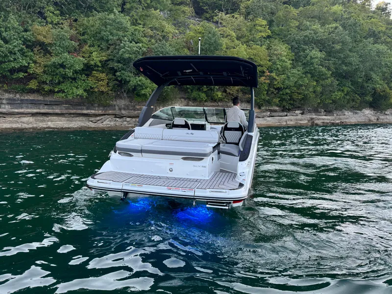 Slide: The Image of 2025 Sea Ray SLX 260 boat cruising on a lake with blue underwater lights. - 5