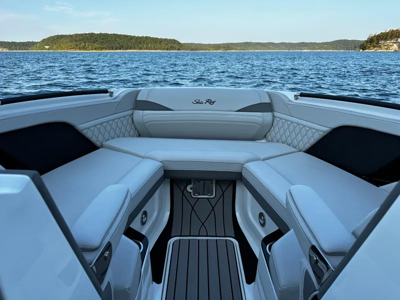 Slide: The Image of 2025 Sea Ray SLX 260 boat interior with luxurious seating on a serene lake. - 6