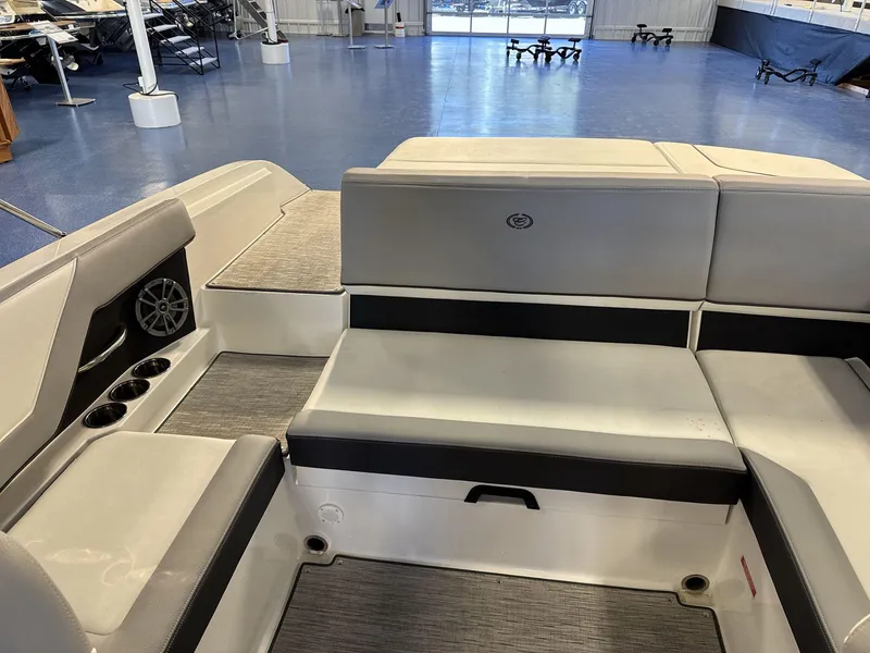 Slide: The Image of 2025 Cobalt CS22 boat interior with gray seating and cup holders in showroom. - 15