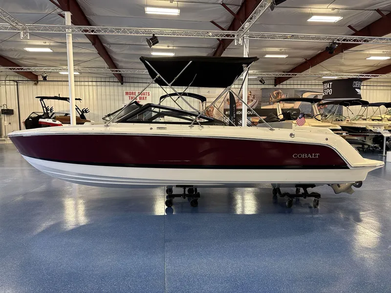 Slide: The Image of 2025 Cobalt CS22 boat with maroon hull displayed indoors on a showroom floor. - 4