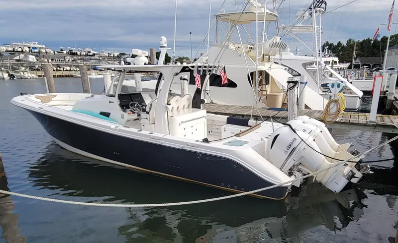The Image of 2018 Edgewater 370CC boat docked in marina, featuring sleek design and powerful engines. - 0
