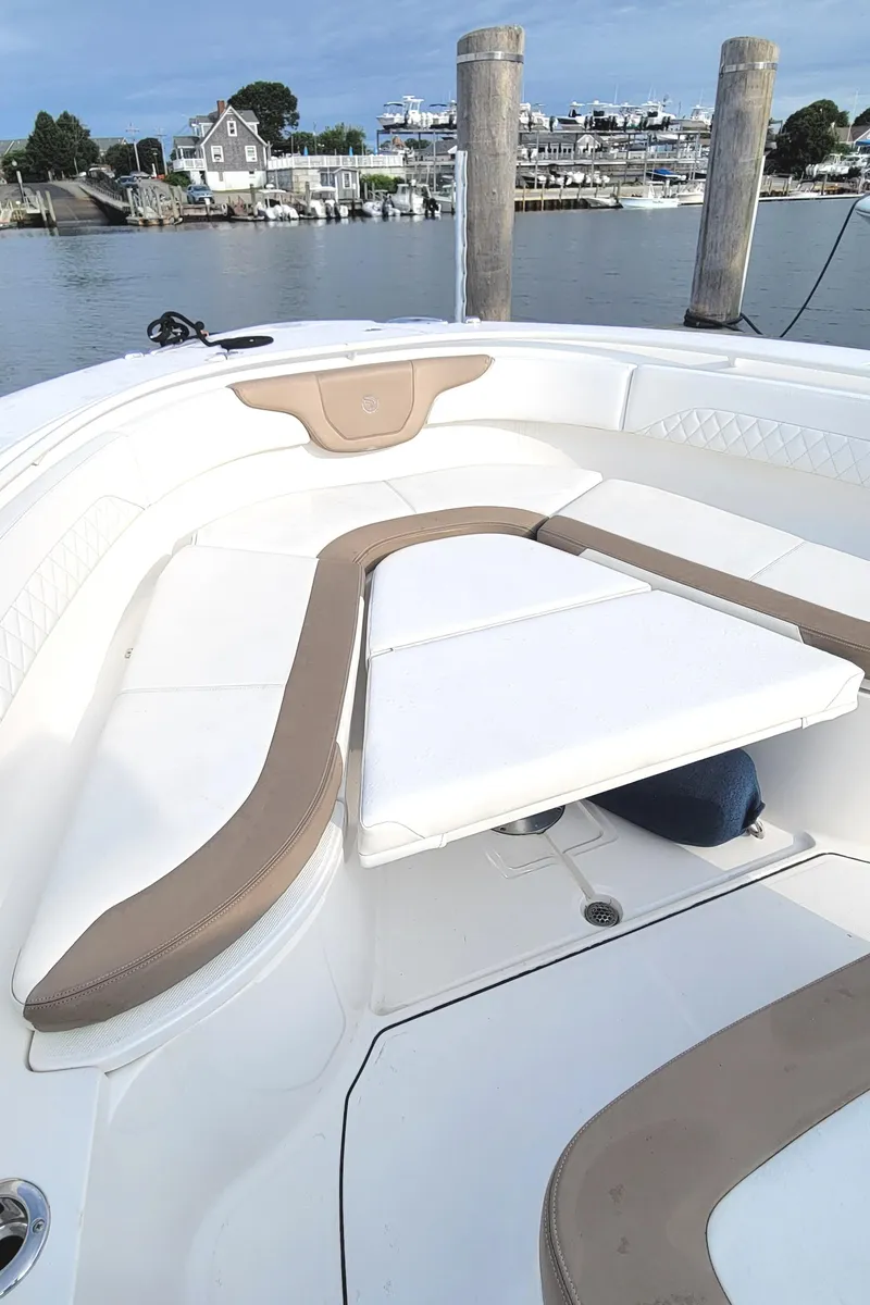 Slide: The Image of 2018 Edgewater 370CC boat with spacious seating, docked by a serene waterfront. - 11