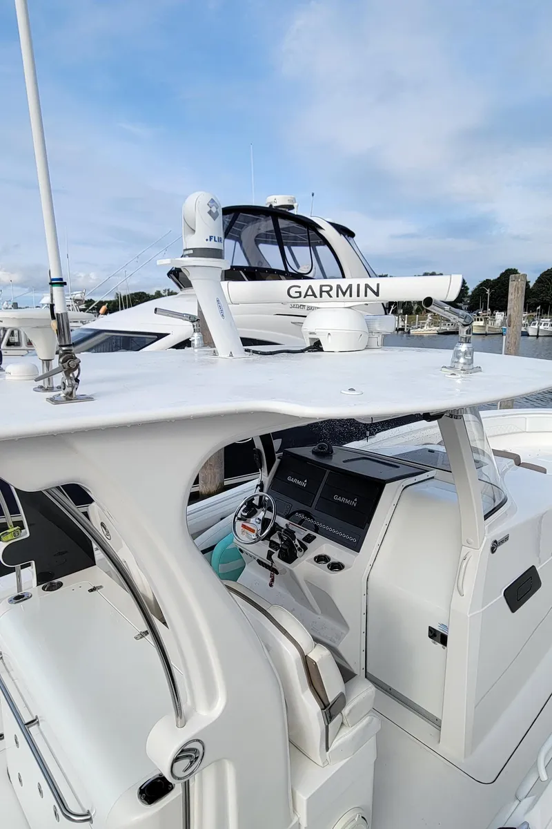 Slide: The Image of 2018 Edgewater 370CC boat with Garmin equipment, docked under a clear sky. - 13