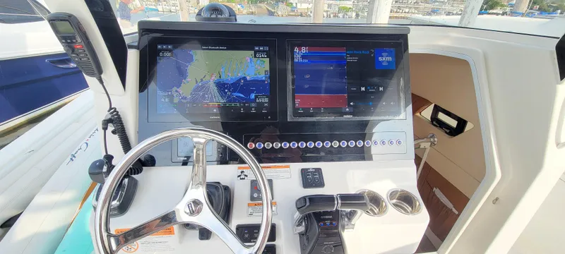 Slide: The Image of 2018 Edgewater 370CC boat dashboard with navigation screens and steering wheel. - 4