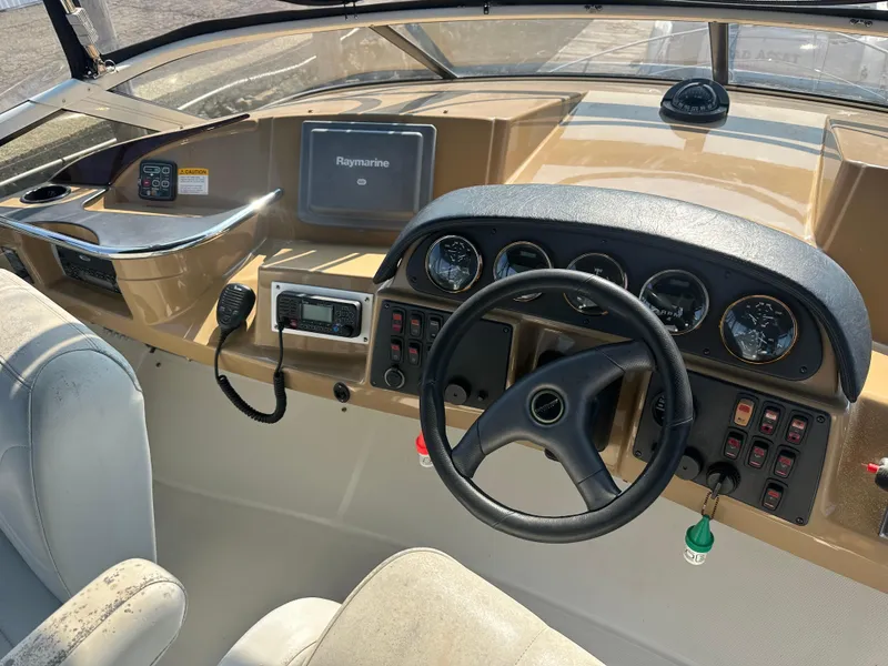 Slide: The Image of 2004 Carver 420 Mariner helm with steering wheel, gauges, and navigation equipment. - 13