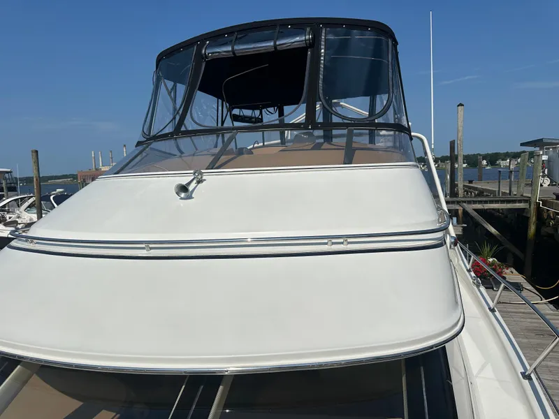 Slide: The Image of 2004 Carver 420 Mariner yacht docked at a marina under clear blue skies. - 18