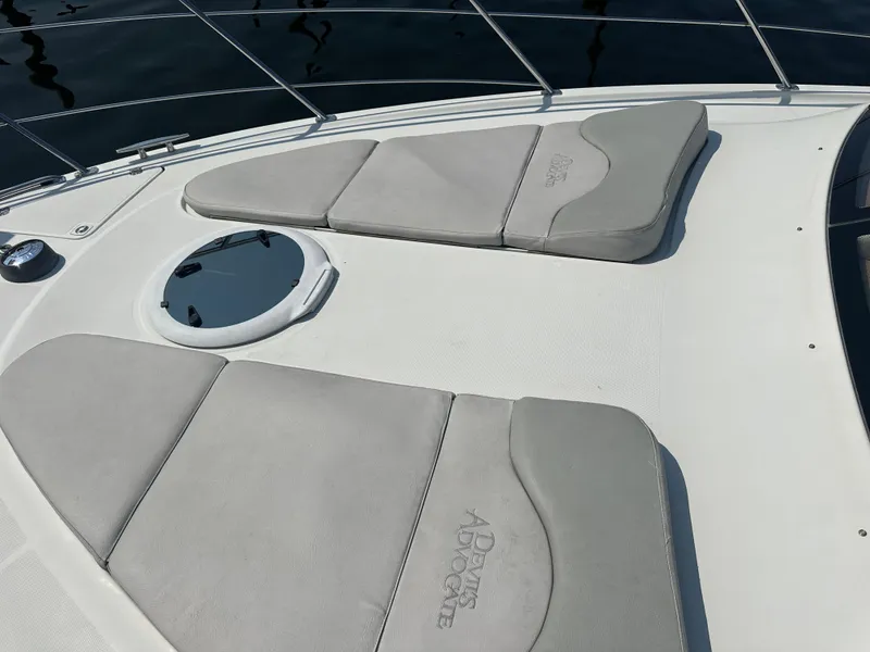 Slide: The Image of 2004 Carver 420 Mariner boat deck with cushioned sun pads and a circular hatch. - 19