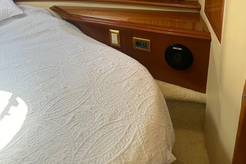 Slide: The Image of Interior of 2004 Carver 420 Mariner with quilted bedding and wooden paneling. - 24