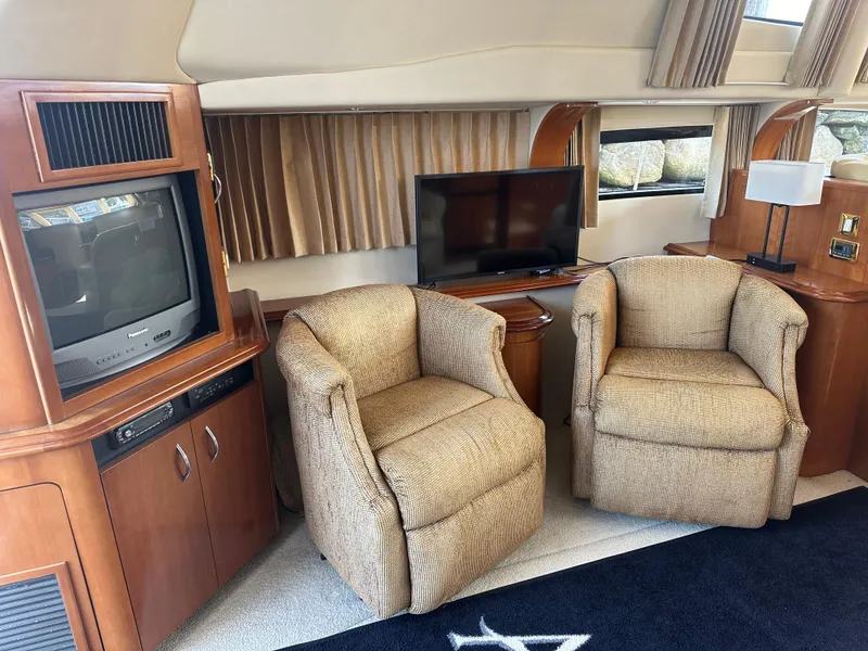 Slide: The Image of Interior of 2004 Carver 420 Mariner yacht with cozy seating and entertainment area. - 4
