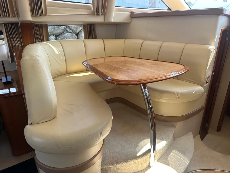 Slide: The Image of Interior of 2004 Carver 420 Mariner with beige leather seating and wooden table. - 7