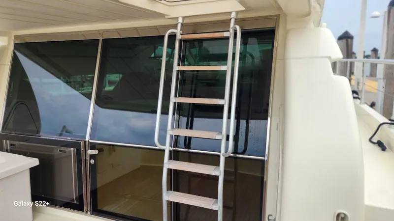 Slide: The Image of 1998 Ferretti Yachts 55 Motor Yacht with exterior ladder and tinted windows. - 2