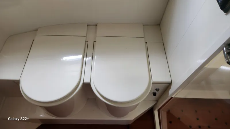 Slide: The Image of Two closed white toilet seats in a 1998 Ferretti Yachts 55 Motor Yacht bathroom. - 20