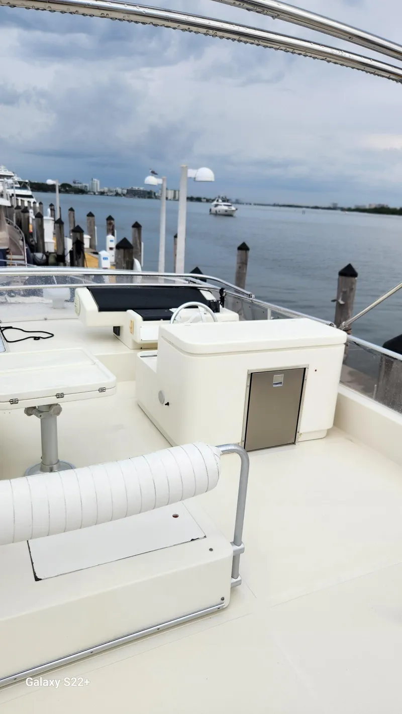 Slide: The Image of 1998 Ferretti Yachts 55 Motor Yacht docked by a serene waterfront. - 24