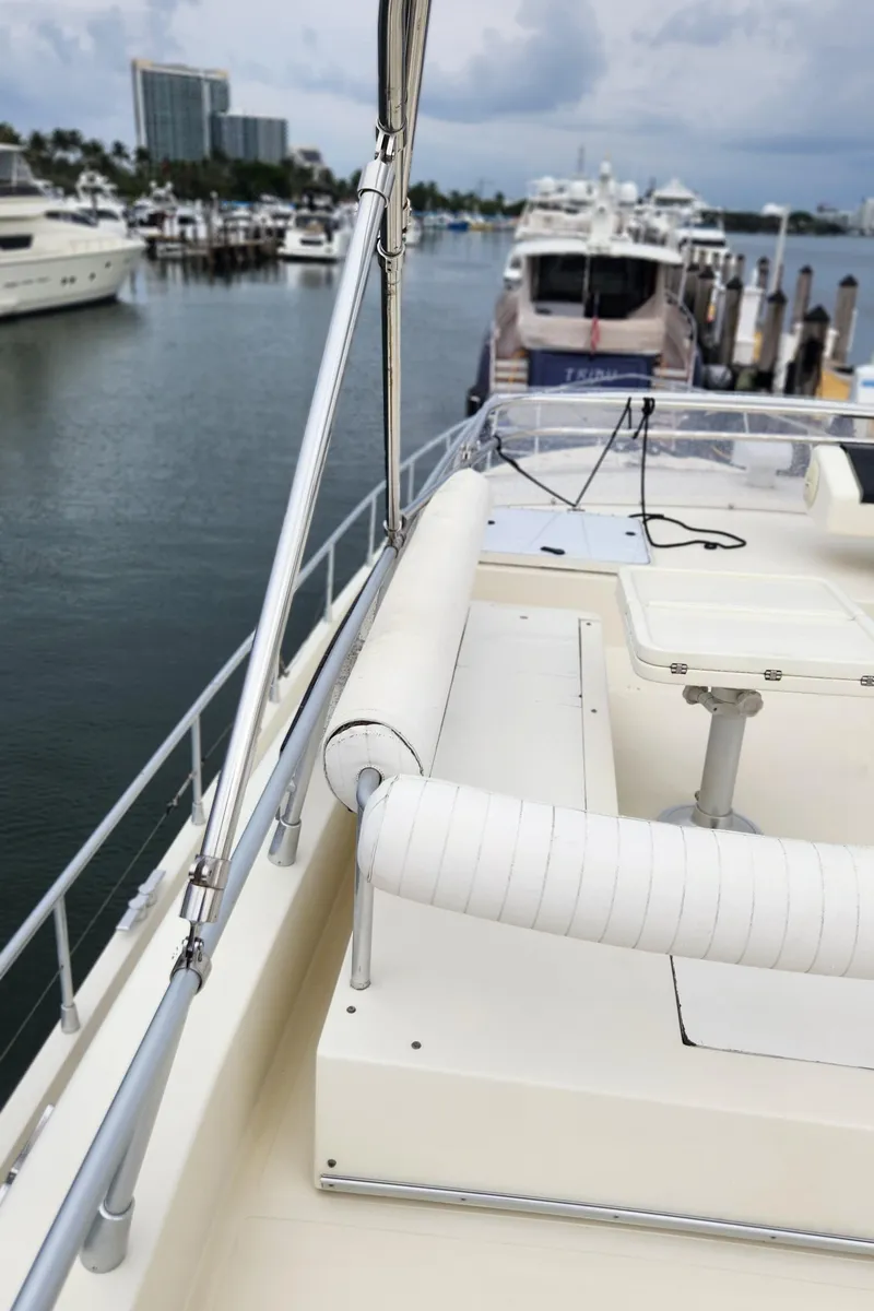 Slide: The Image of 1998 Ferretti Yachts 55 Motor Yacht docked in a marina, featuring spacious deck seating. - 42