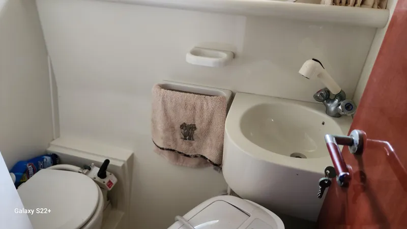 Slide: The Image of Bathroom interior of 1998 Ferretti Yachts 55 Motor Yacht, featuring sink and toilet. - 6