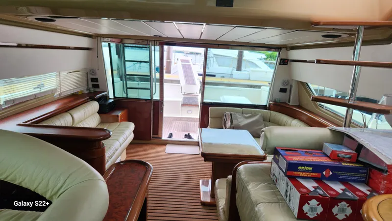 Slide: The Image of Interior of 1998 Ferretti Yachts 55 Motor Yacht with luxurious seating and wooden accents. - 9