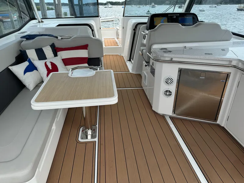 Slide: The Image of 2020 Aquila 36 Sport interior with seating, table, and kitchenette on teak flooring. - 11