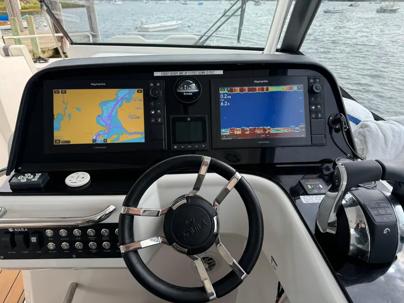Slide: The Image of Aquila 36 Sport 2020 boat dashboard with navigation screens and controls. - 21