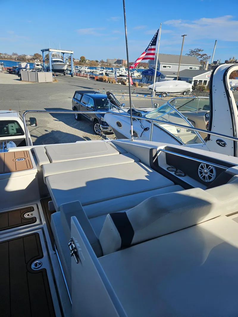 Slide: The Image of 2020 Aquila 36 Sport yacht with spacious deck, docked near vehicles and American flag. - 29