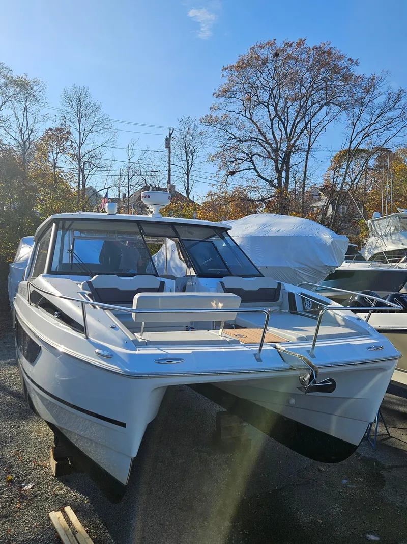Slide: The Image of 2020 Aquila 36 Sport boat on display outdoors, surrounded by trees and other boats. - 4