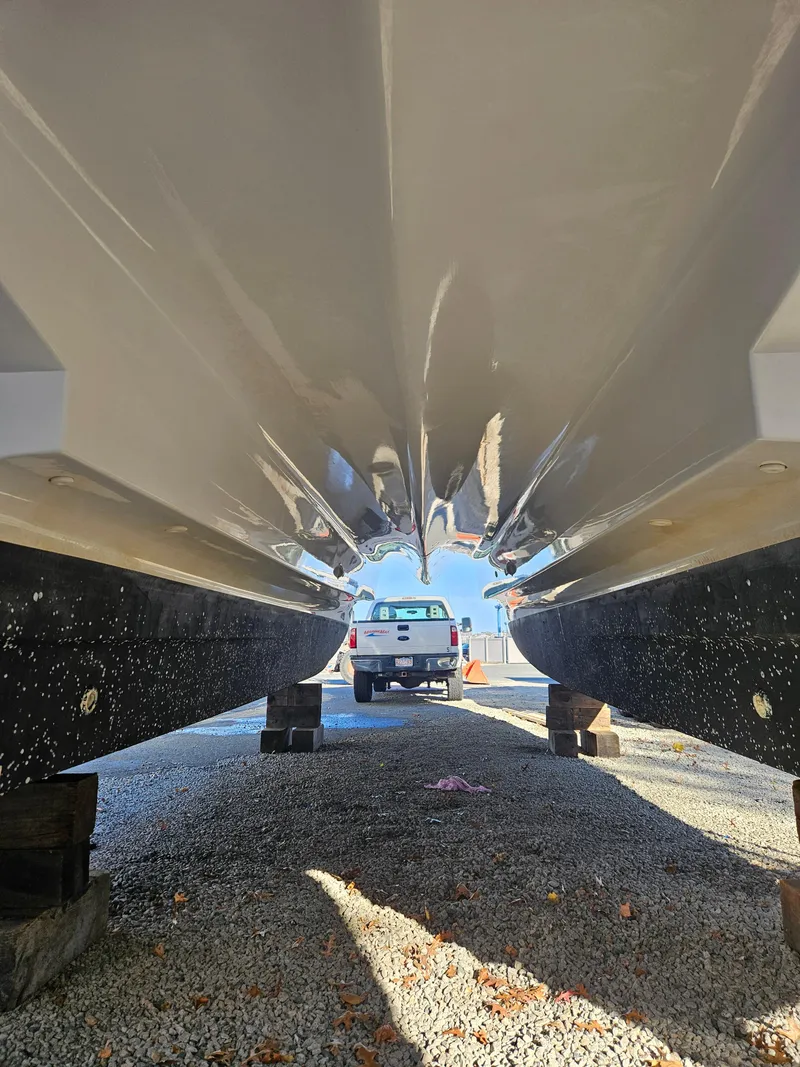 Slide: The Image of 2020 Aquila 36 Sport catamaran hulls on dry dock, with truck in background. - 5