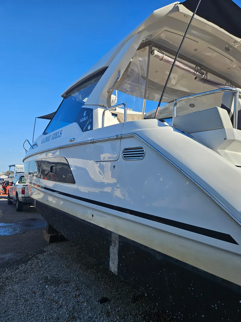 Slide: The Image of 2020 Aquila 36 Sport boat with sleek design, docked under clear blue sky. - 6