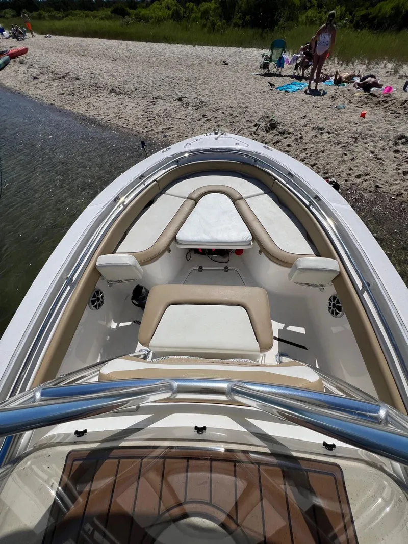 Slide: The Image of 2018 Pioneer 222 Islander boat docked on a sandy beach with people nearby. - 7
