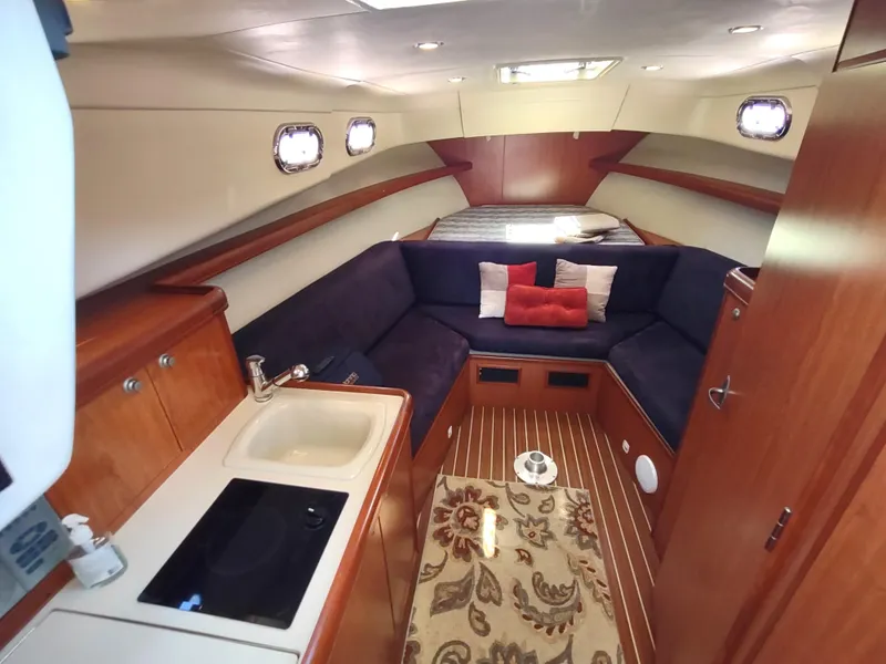 Slide: The Image of 2008 Mainship 30 Pilot II Sedan interior with cozy seating and kitchenette. - 28
