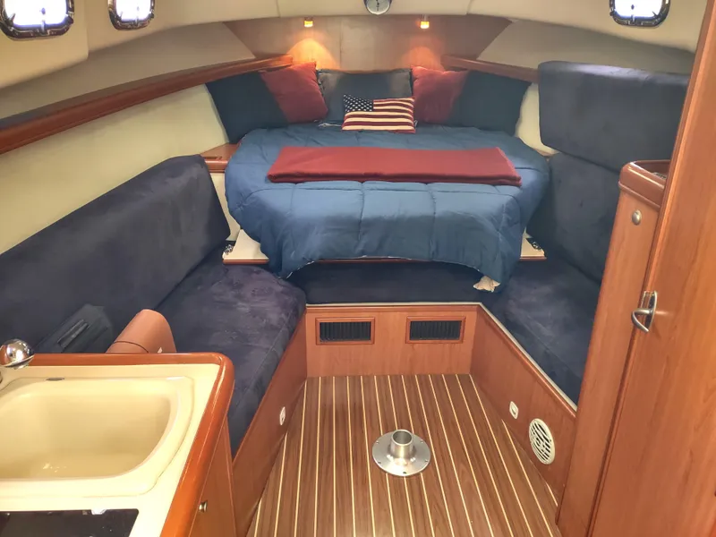 Slide: The Image of 2008 Mainship 30 Pilot II Sedan cabin with cozy bed and wooden interior. - 29