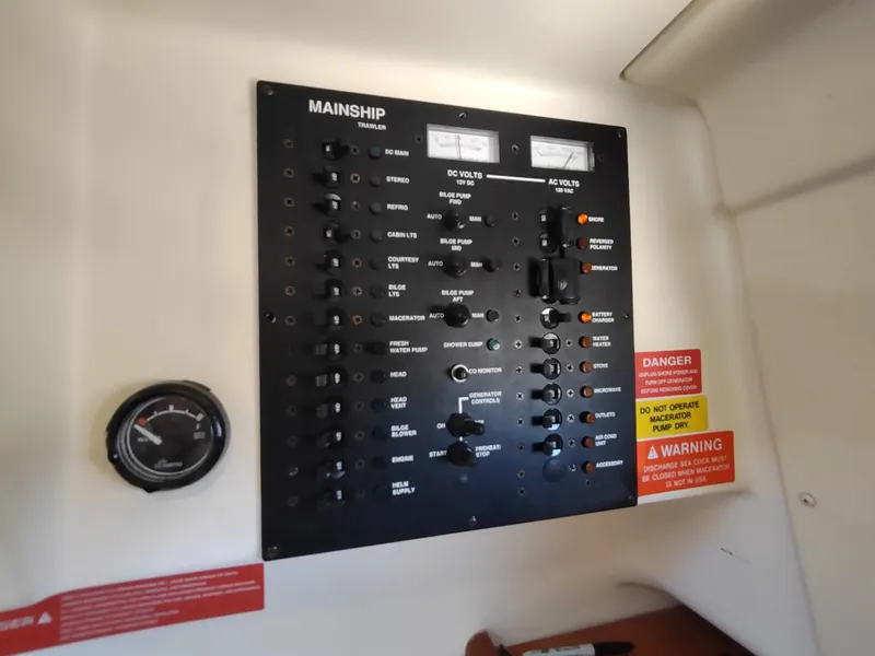 Slide: The Image of Control panel of 2008 Mainship 30 Pilot II Sedan boat with gauges and warning labels. - 33
