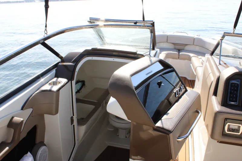 Slide: The Image of 2019 Formula 270 Bowrider interior with seating and helm, on calm water. - 11