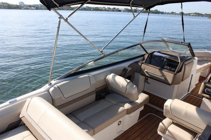 Slide: The Image of 2019 Formula 270 Bowrider boat interior with beige seating and sleek design on calm water. - 3