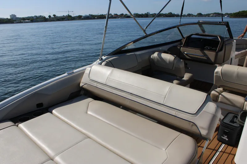 Slide: The Image of 2019 Formula 270 Bowrider boat interior with beige seating on a calm lake. - 4