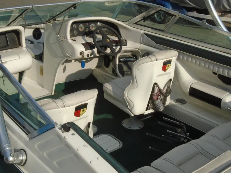 Slide: The Image of Interior of a 1994 Mariah 211 Shabah boat, featuring white seating and dashboard controls. - 7