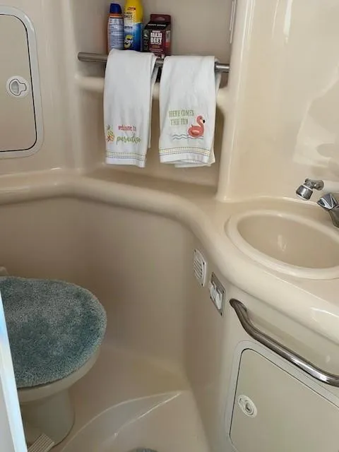 Slide: The Image of 2000 Sea Ray Cruiser 310 Sundancer bathroom with sink, toilet, and towels. - 13