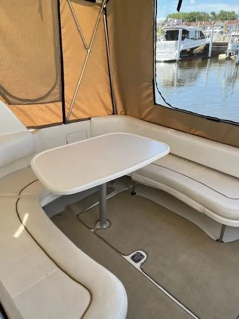Slide: The Image of 2000 Sea Ray Cruiser 310 Sundancer interior with seating and table, docked at marina. - 5