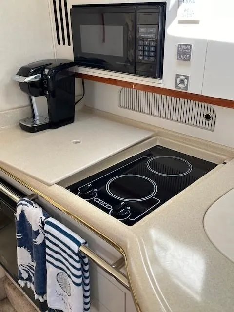 Slide: The Image of 2000 Sea Ray Cruiser 310 Sundancer kitchen with stove, microwave, and coffee maker. - 7