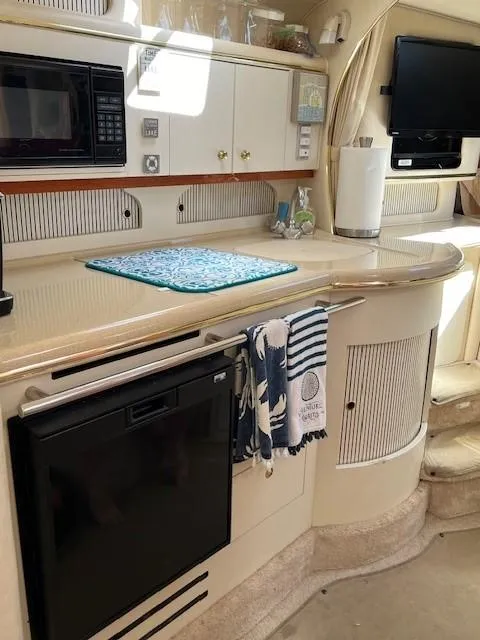 Slide: The Image of 2000 Sea Ray Cruiser 310 Sundancer interior kitchen with appliances and modern amenities. - 8