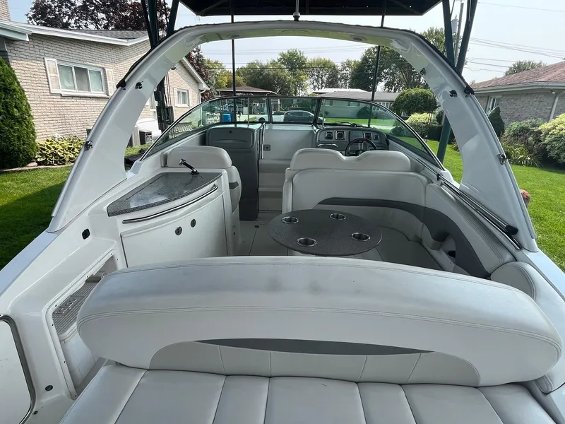 Slide: The Image of 2010 Chaparral 275 SSi boat interior with seating and dashboard, parked in a residential yard. - 12