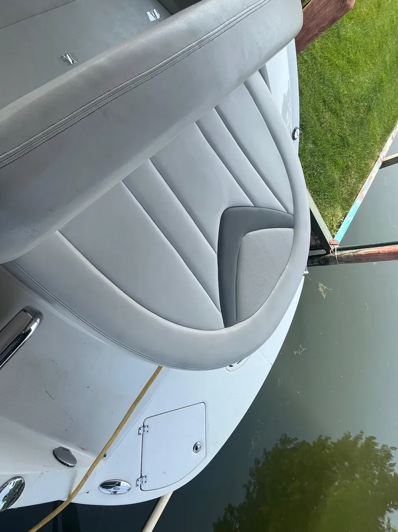 Slide: The Image of 2010 Chaparral 275 SSi boat with sleek seating, docked by the water. - 15