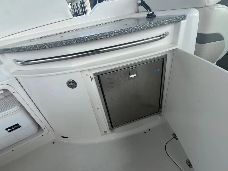 Slide: The Image of 2010 Chaparral 275 SSi boat interior with stainless steel mini fridge and countertop. - 17