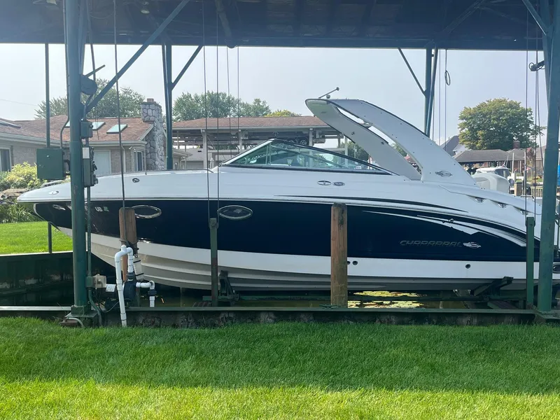 Slide: The Image of 2010 Chaparral 275 SSi boat on a lift, docked in a covered marina. - 2