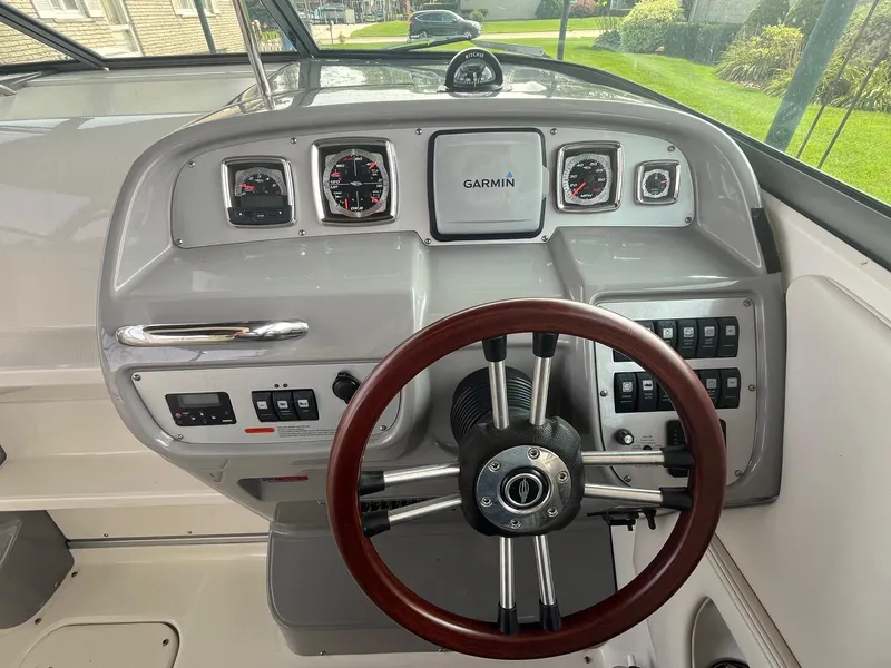 Slide: The Image of 2010 Chaparral 275 SSi boat dashboard with Garmin navigation and wood-accented steering wheel. - 20