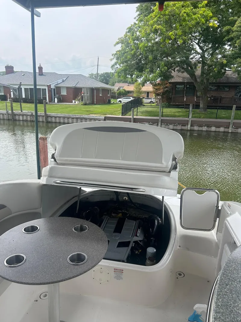 Slide: The Image of 2010 Chaparral 275 SSi boat with open engine compartment, docked by a waterfront home. - 29