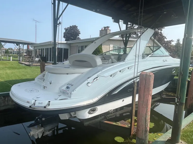 Slide: The Image of 2010 Chaparral 275 SSi boat docked under a canopy, showcasing sleek design and white exterior. - 3
